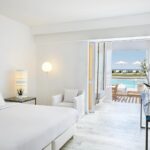 GrecotelWhitePalace - 39 Lux Me Swim Up Bungalows with sharing pool and sea view bedroom with large glass doors_72dpi